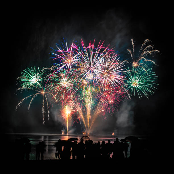 istock Beautiful large and colorful fireworks with unrecognizable crowd silhouettes people watching the show 839171826