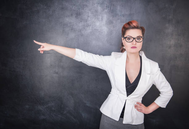 istock Serious woman teacher pointing out 839177998