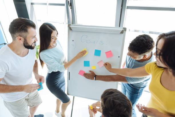istock Delighted positive people putting sticky notes to the whiteboard 839199446