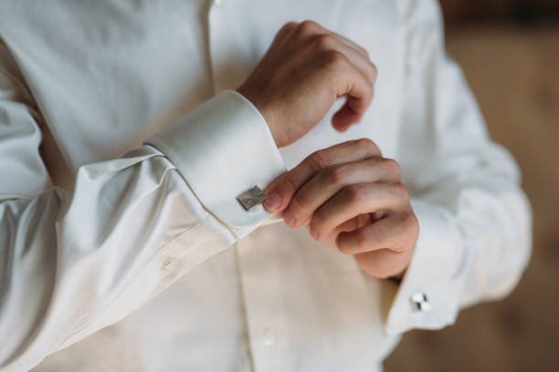 mani da sposo che indossano gemelli. elegante gentleman clother, camicia bianca e cintura marrone - cuff link suit men wedding foto e immagini stock