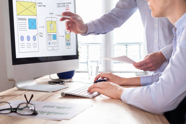 Website development team sketching wireframe layout for responsive web content Website development team sketching wireframe layout design for responsive web content, two UI/UX front end designers in office website design stock pictures, royalty-free photos images