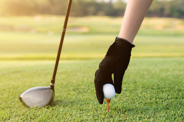 istock Hand placing a tee with golf ball. Hand hold golf ball with tee on course, close-up 839216786