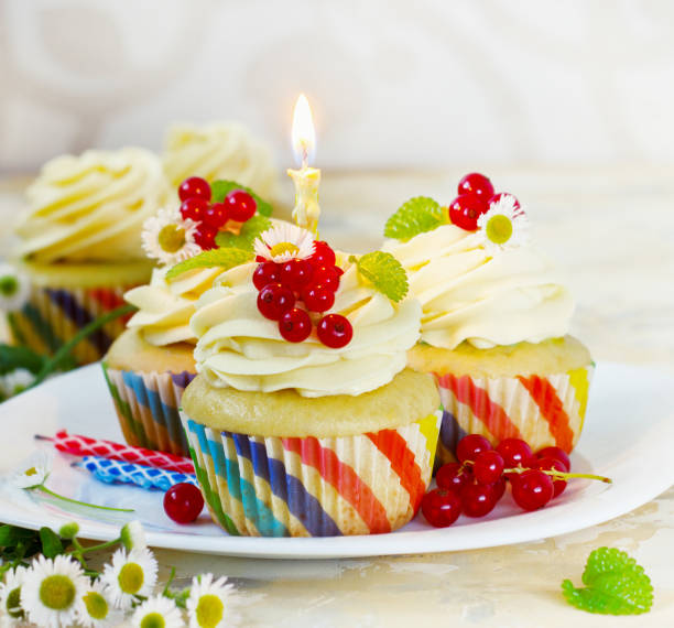 istock Gentle cupcake with cream and berries nd a candle a light background 839229730