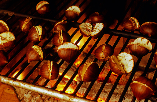 Chestnuts in the holed pan over the embers, winter seasonal food concept