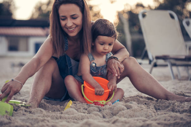 istock Mother and daughter playing in sand 839272796