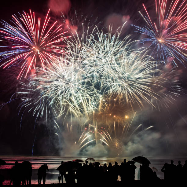 istock Beautiful large and colorful fireworks with unrecognizable crowd silhouettes people watching the show 839273704