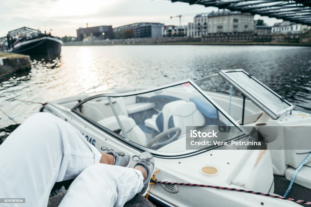 woman sits on piar looking on the river woman sits on piar looking on the river boat on the background Amphibious Vehicle Stock Photo