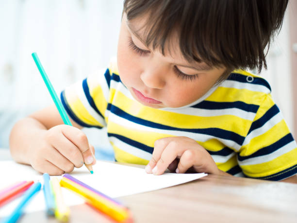 istock The child paints with colored pencils 839290714