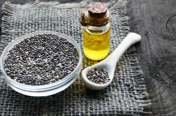 Chia seeds and chia oil on old wooden background.Organic chia seed oil.Salvia hispanica seeds.Healthy food,superfood or bodycare concept. Chia seeds and chia oil on old wooden background.Organic chia seed oil.Salvia hispanica seeds.Healthy food,superfood or bodycare concept.Selective focus. salvia hispanica plant stock pictures, royalty-free photos & images