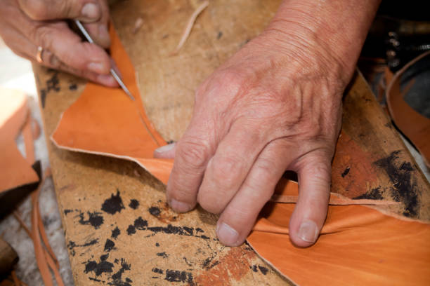 istock Shoemaker's hands manufacturing leather boots and shoes. 839295202