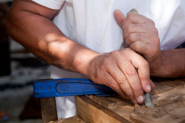 istock Craftsman's hands holding chisel, carving a piece of wood. 839295294
