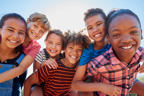 Six pre-teen friends piggybacking in a park, close up portrait Six pre-teen friends piggybacking in a park, close up portrait multiracial group stock pictures, royalty-free photos & images