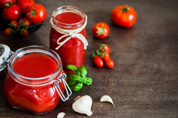 tomatensauce in ein gefäß - tomatensoße stock-fotos und bilder