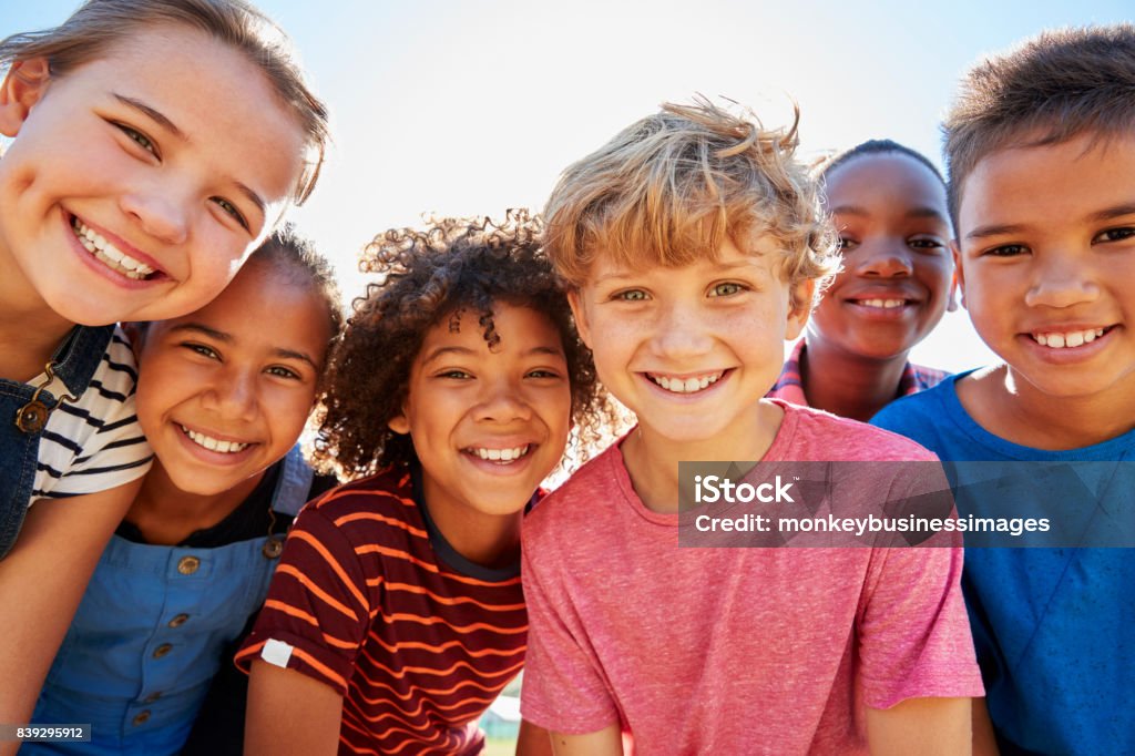 Cerca de amigos adolescentes en un parque sonriendo a la cámara - Foto de stock de Niño libre de derechos