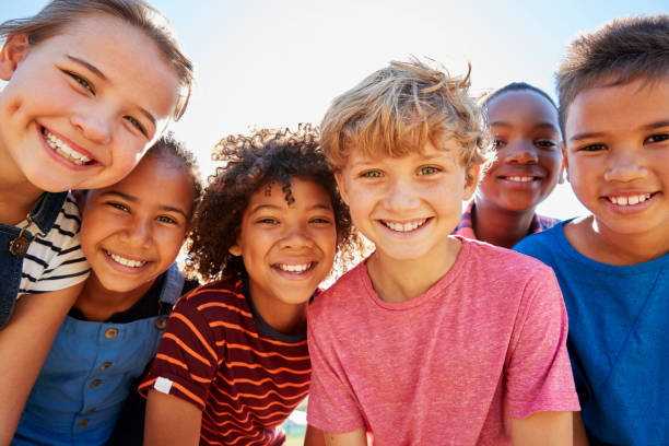Close up of pre-teen friends in a park smiling to camera Close up of pre-teen friends in a park smiling to camera leisure activity photos stock pictures, royalty-free photos & images