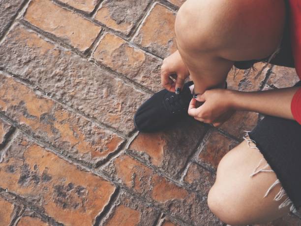 istock Woman tying running shoe laces 839304360