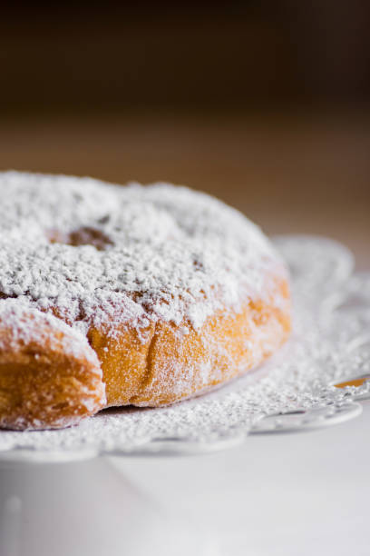 istock Traditional Spanish or Philippine pastry ensaimada. Powdered, on white cake stand. Cozy rustic kitchen interior, minimalist style. 839305048