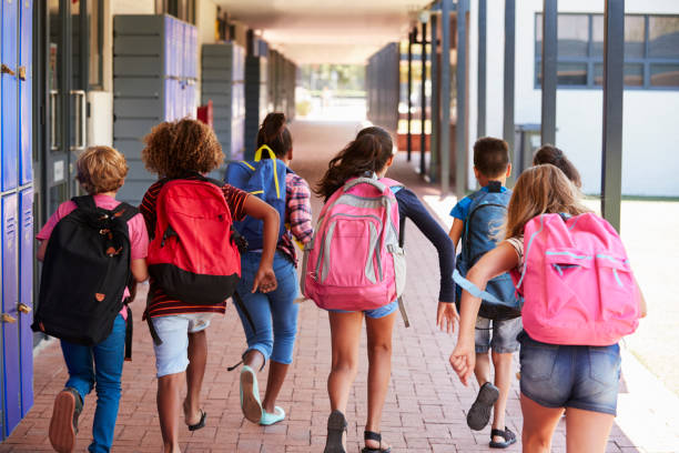 istock School kids running in elementary school hallway, back view 839325242