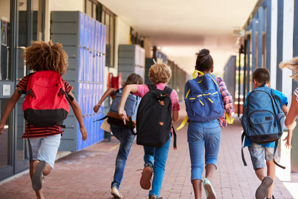 istock School kids running in elementary school hallway, back view 839325944