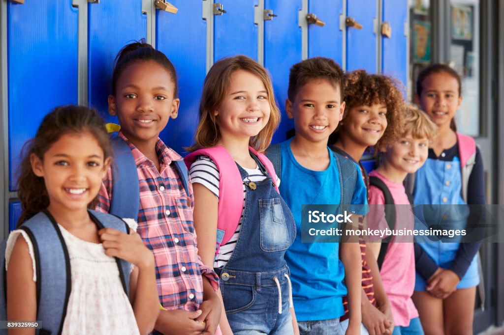 Niños de la escuela frente de armarios en el pasillo de la escuela primaria - Foto de stock de Niño libre de derechos