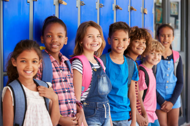 小学校の廊下のロッカーの前に学校の子供たち - elementary school waist up indoors childhood ストックフォトと画像