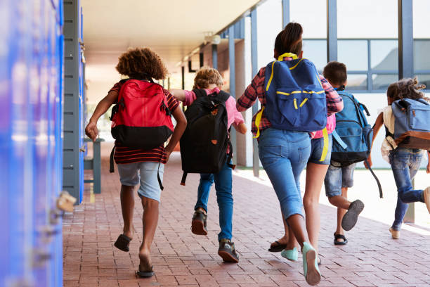 istock School kids running in elementary school hallway, back view 839325954