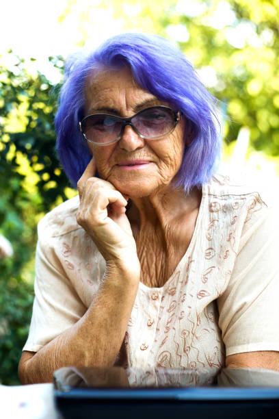 istock Old woman using a laptop outdoor 839332632