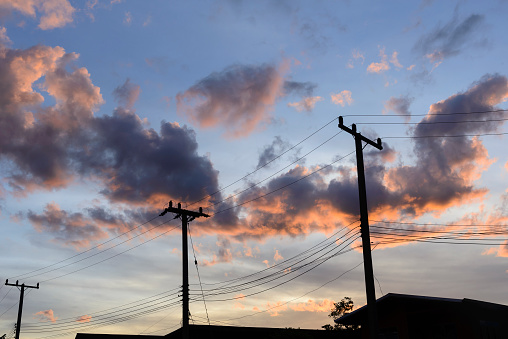 The silhouette scene of electric pole with the twilight sky after sun set.