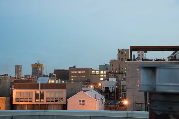 Chicago neighborhood apartment buildings from rooftop. Sunset colors reflected. Brick and industrial materials.