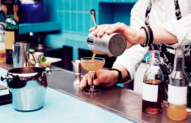 istock Bartender is pouring cocktail from shaker, toned 839360450