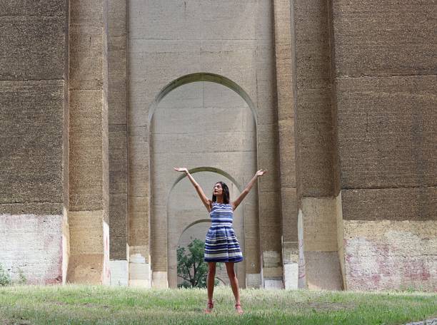istock attractive woman standing in field under stone archway 839364464