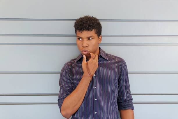 istock Young man standing against a gray wall 839368268