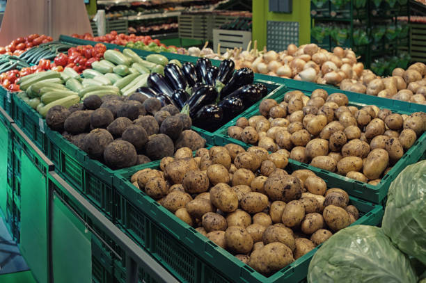 Vegetables in green plastic crates, supermarket food store, toned