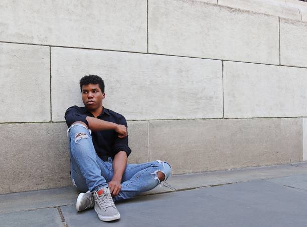 istock Young man sitting outside against concrete wall worried, upset, stressed 839372004