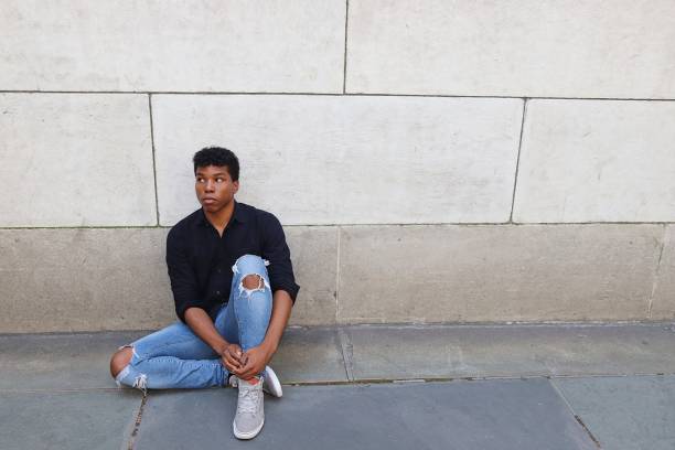 istock Young man sitting outside against concrete wall worried, upset, stressed 839372096