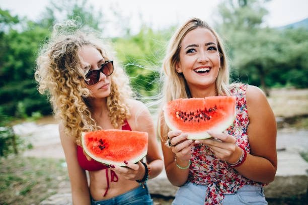 istock Girlfriends laughing and eating watermelon 839372970