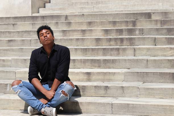 istock Young man sitting on concrete steps with arms in lap 839374110