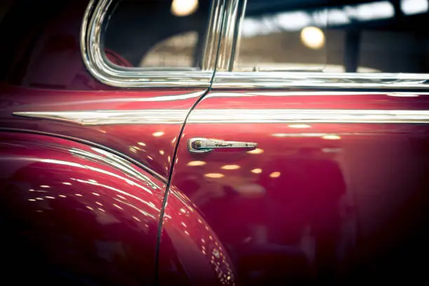 Door and window details of red retro car.