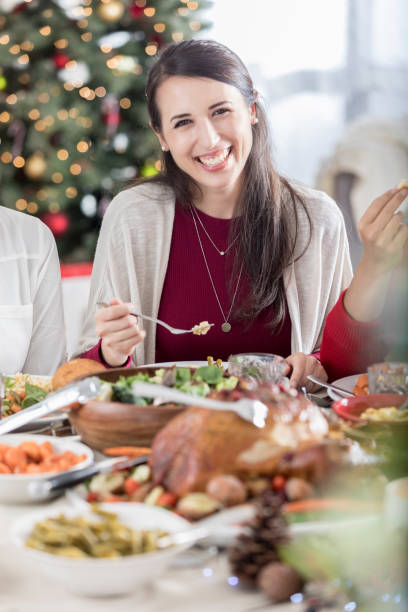 Mid adult woman smiles for camera during Christmas dinner