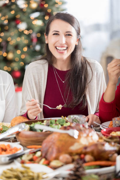 Christmas dinner guest smiles for the camera with fork in hand