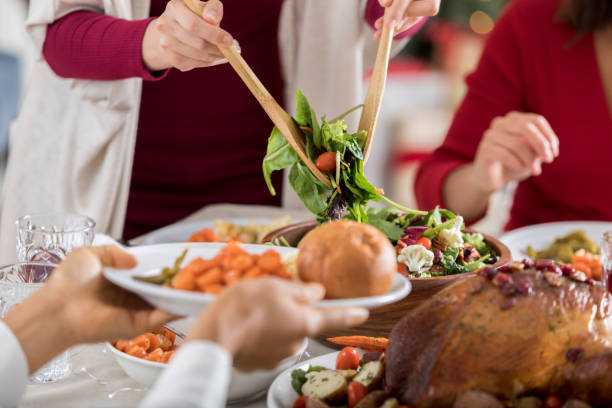 Guest at Christmas dinner is served salad by hostess