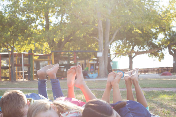 istock Happy children relaxing on grassy field at park 839384564