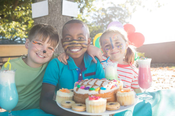 istock Happy children with face paint having food and drinks at park 839384848