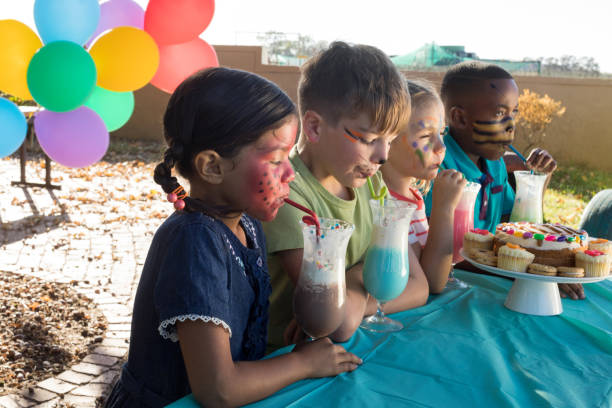 istock Happy children enjoying food and drinks at park 839384980