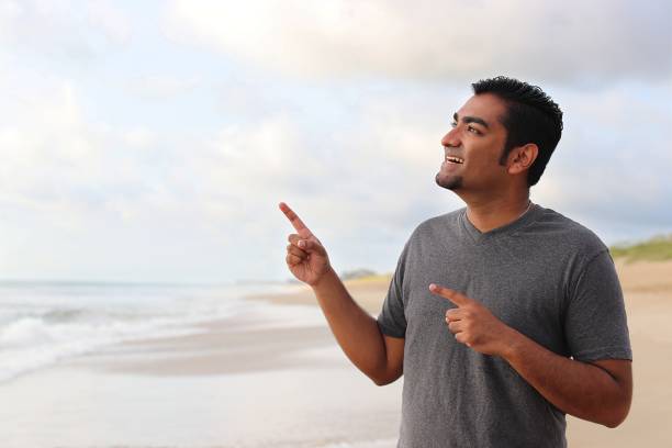 istock Attractive man standing on ocean beach 839389090
