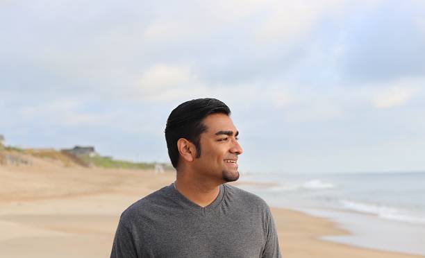 istock successful young man standing on beach during sunrise 839389356