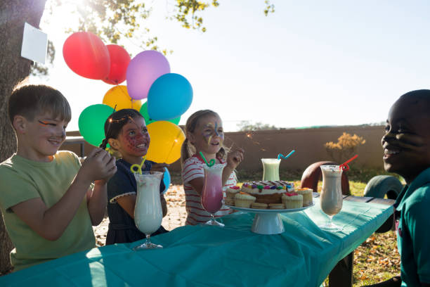istock Happy children talking while having food and drinks against sky at table 839391802