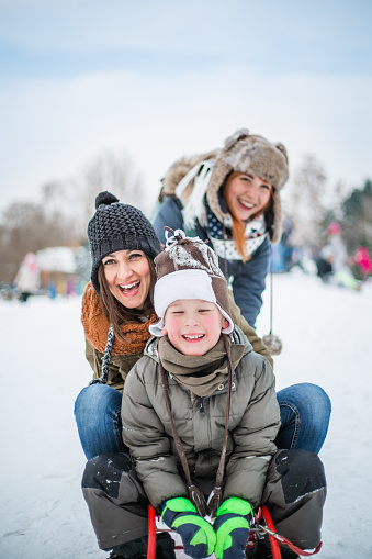 Two young woman and child having fun on snow