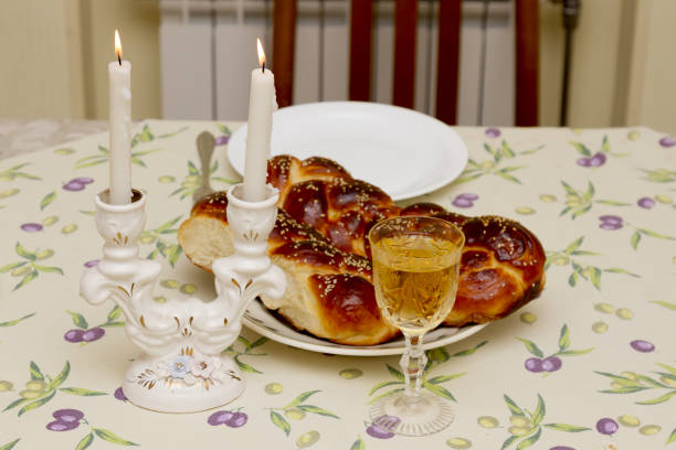 istock Shabbat candles in glass candlesticks with blurred covered challah background. Isolated on black. Copy space. 839406568