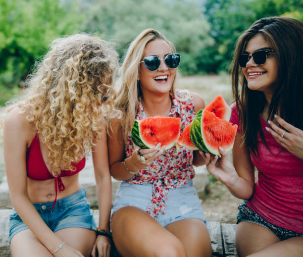 istock Girlfriends laughing and eating watermelon 839410210